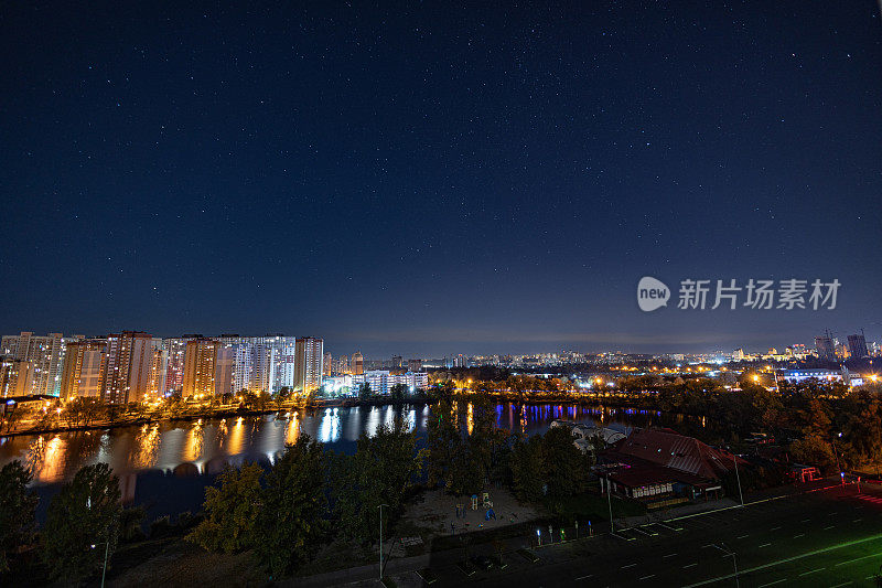 星空下的大城市夜景。令人敬畏的明亮，多色灯宵禁在空旷的街道。公寓大楼在卧室镇地区。Kyiv in mid october 2022. 乌克兰。